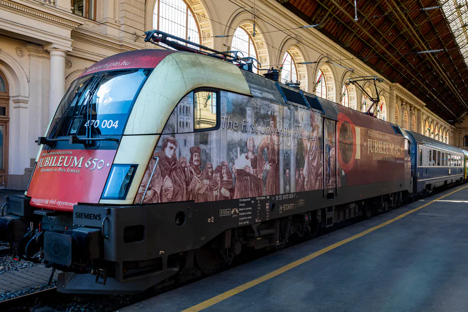 Modern Hungarian train with decorative artwork waiting at Budapest Keleti station platform