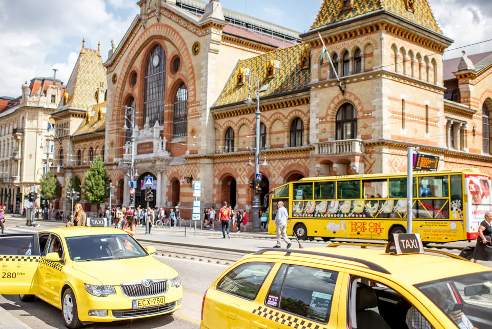 Yellow taxis lined up outside the historic Great Market Hall in Budapest