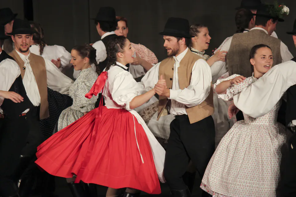 Traditional Hungarian folk dancers in embroidered costumes performing in historic square
