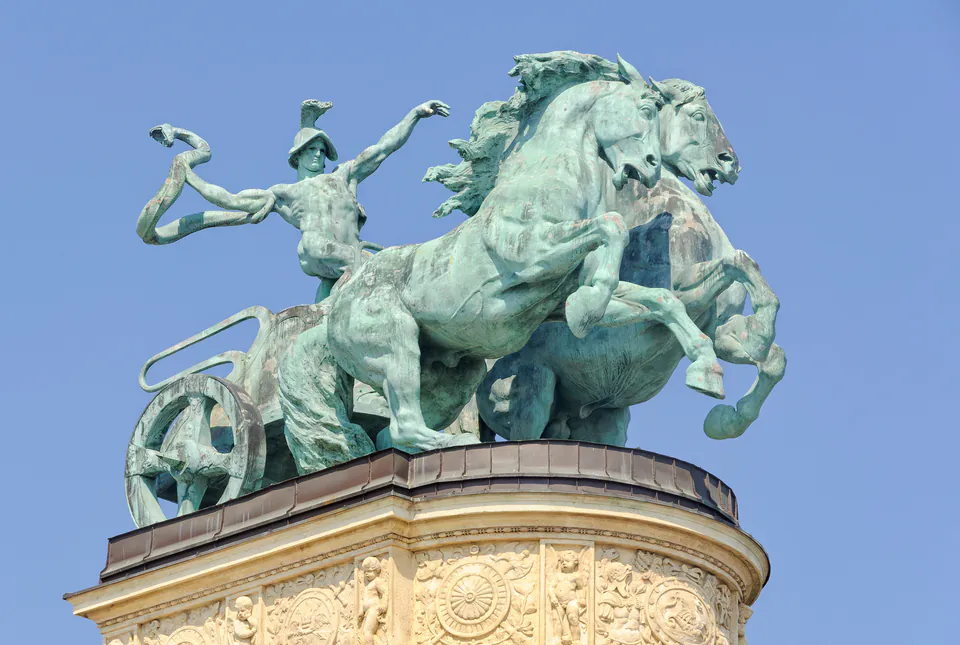 Bronze chariot sculpture with horses and allegorical figure atop Heroes' Square colonnade