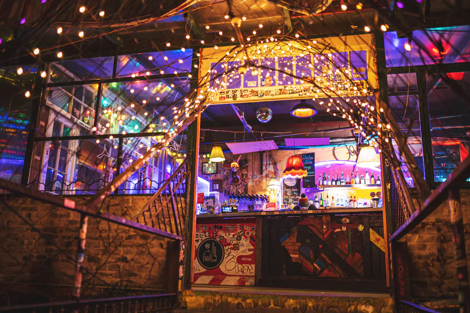 Illuminated courtyard bar with string lights and colorful lighting at Szimpla Kert ruin pub