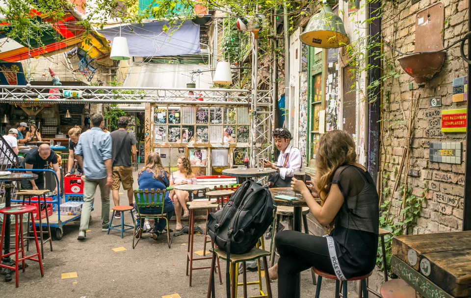 Outdoor courtyard seating area at a ruin pub with casual visitors and eclectic decorations