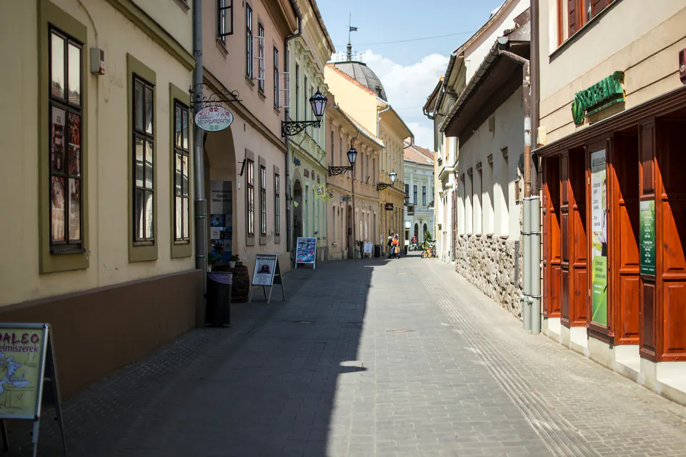 Narrow historic street in Eger with pastel-colored buildings and traditional Hungarian architecture