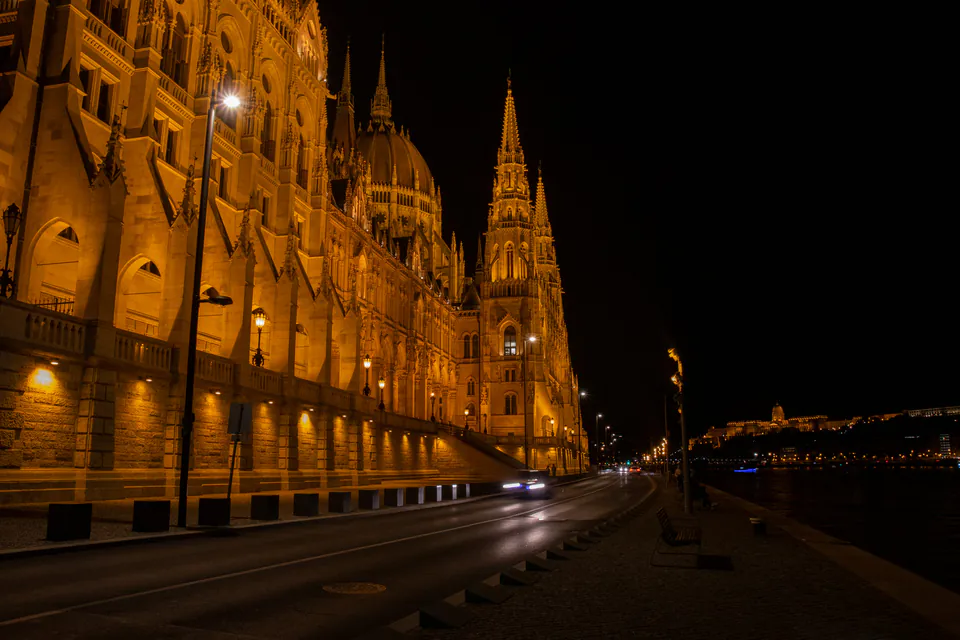 Parliament building illuminated at night with golden lights along its facade
