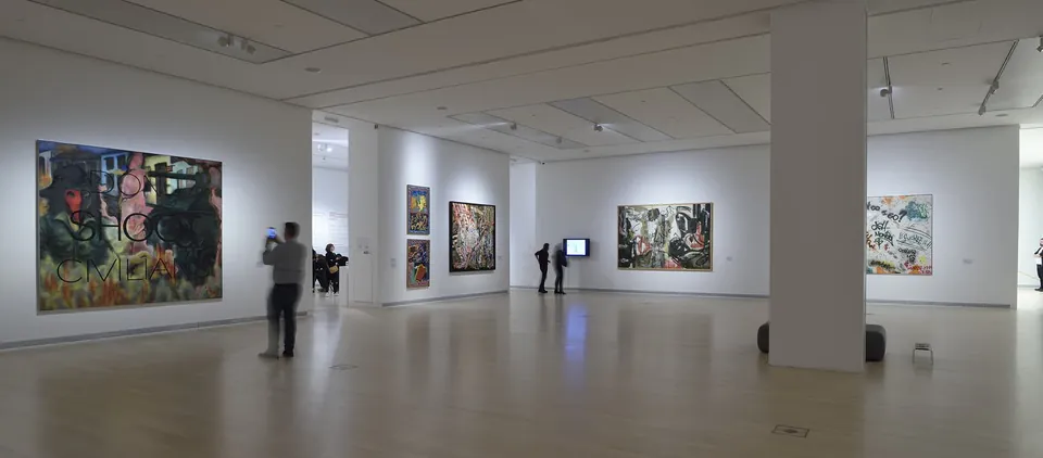 White gallery space with large contemporary paintings on walls and visitors viewing modern art exhibits