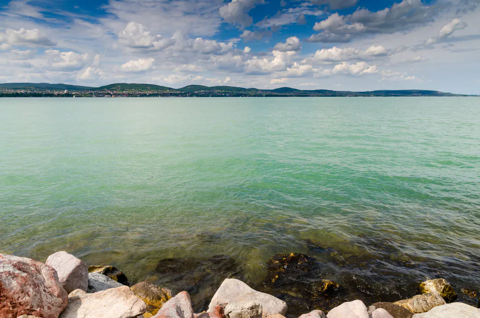 View of Lake Balaton showing contrasting water depths and rocky northern shoreline