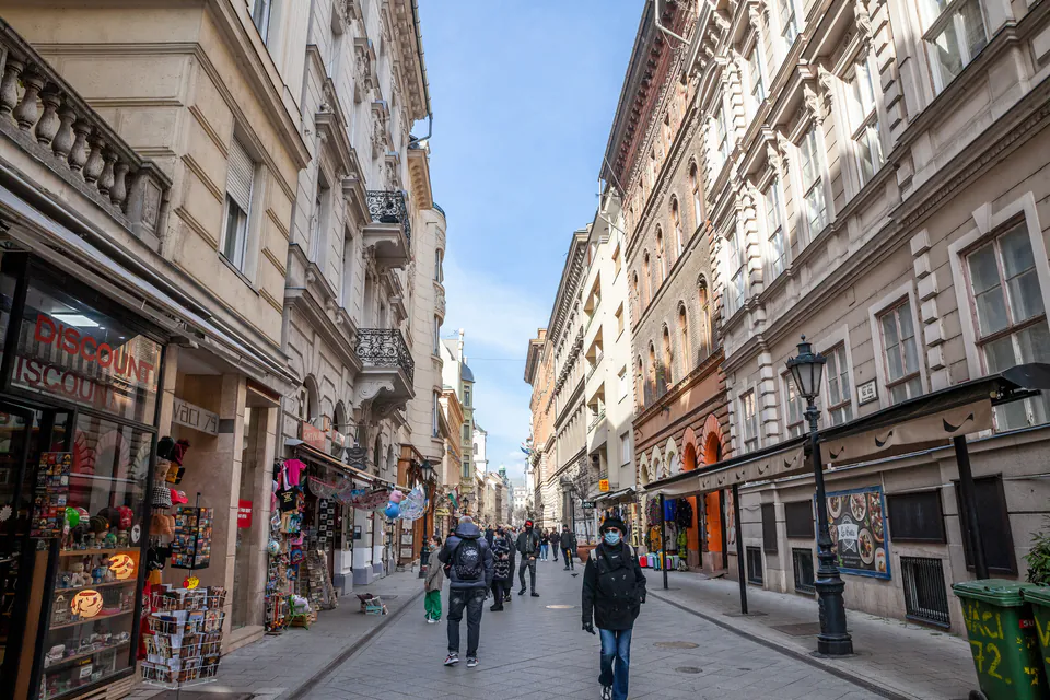 Historic pedestrian shopping street lined with ornate buildings and retail stores