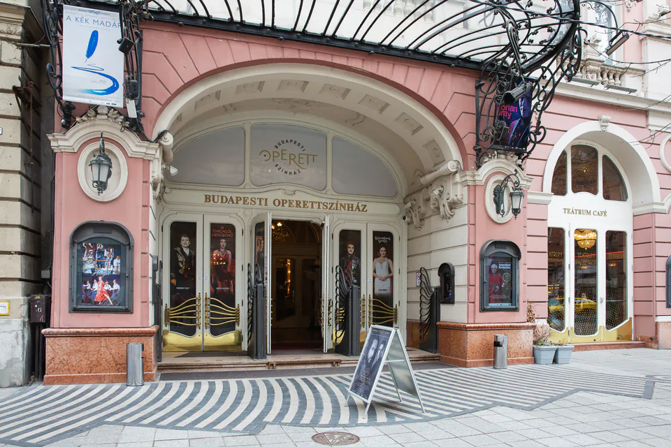 Art nouveau entrance of Budapest Operetta Theatre with pink facade and ornate iron canopy