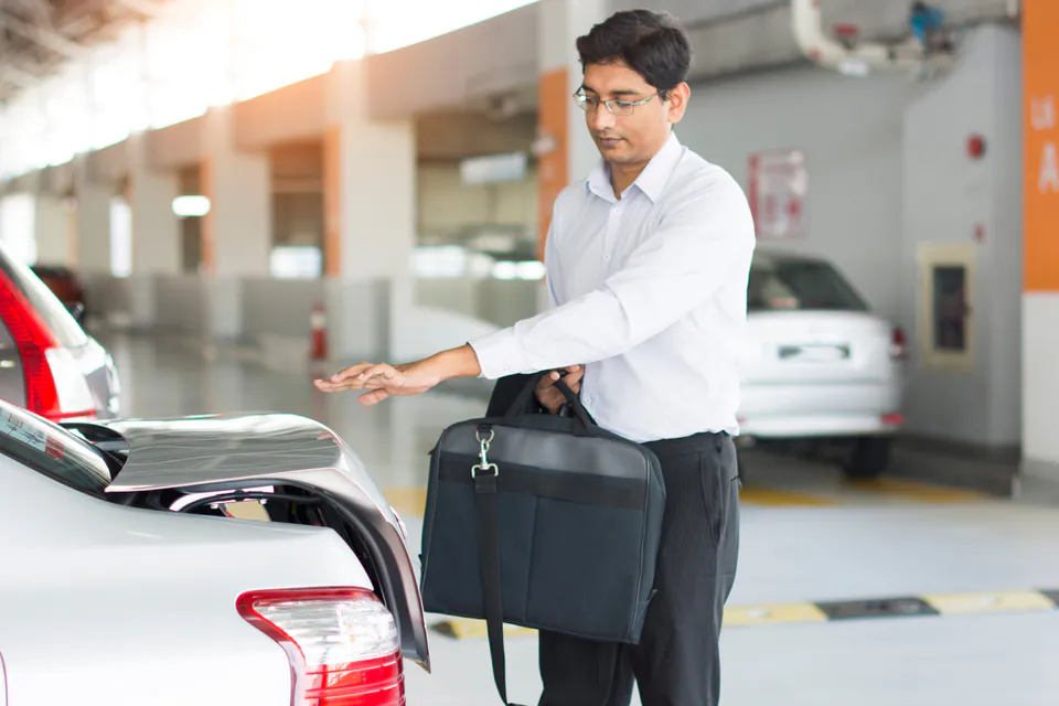 Professional examining a rental car in a modern parking garage