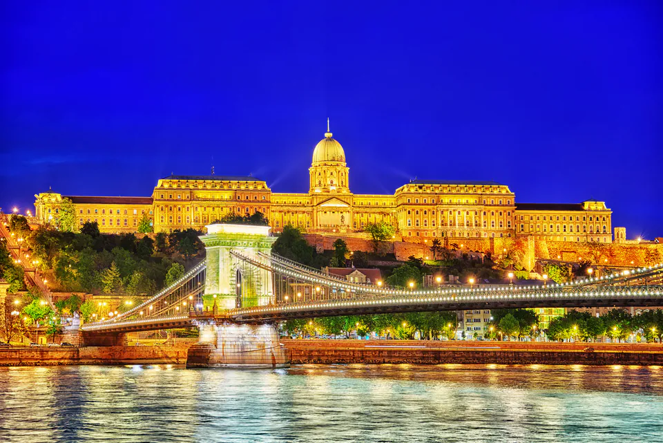 Illuminated Buda Castle and Chain Bridge reflecting in the Danube River at night