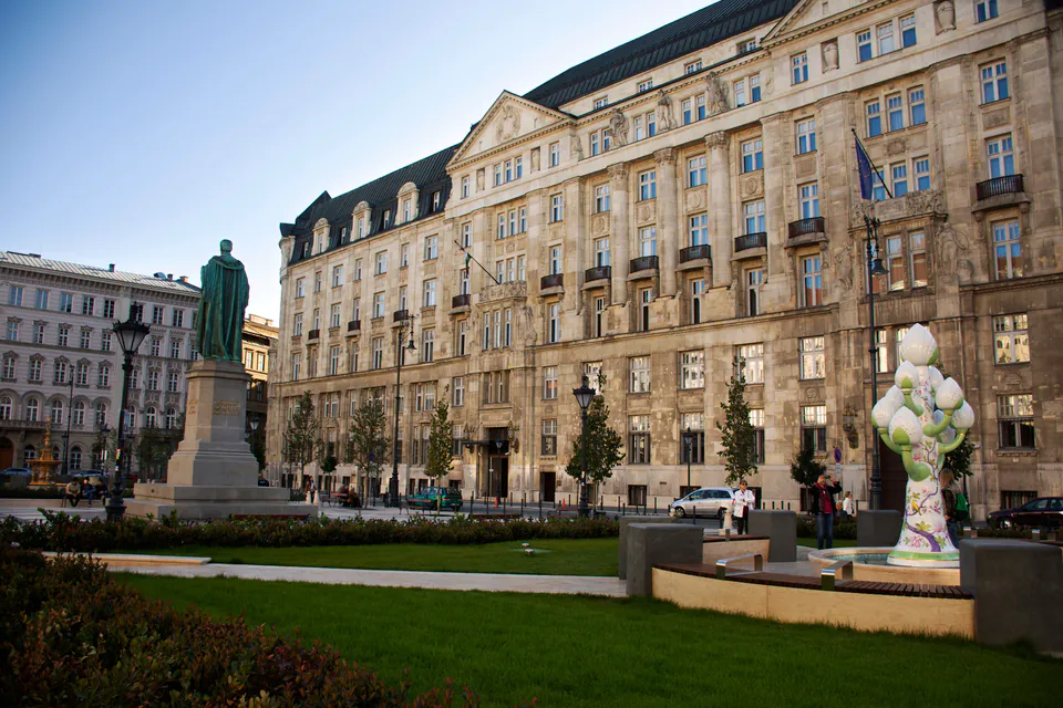 Tour group meeting point at a historic square with grand architecture and statues
