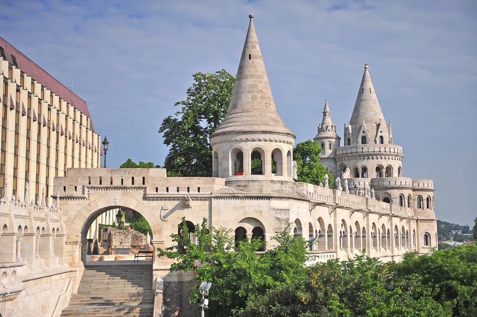 White stone towers and arches of Fisherman's Bastion with decorative turrets against blue sky