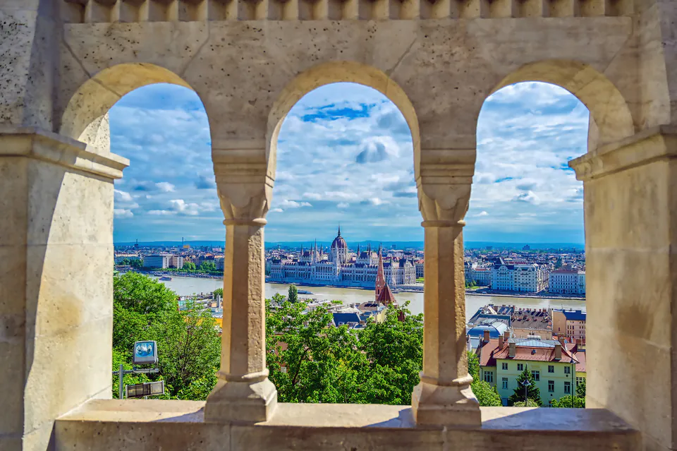 View of Budapest Parliament and Danube through three stone arches of Fisherman's Bastion