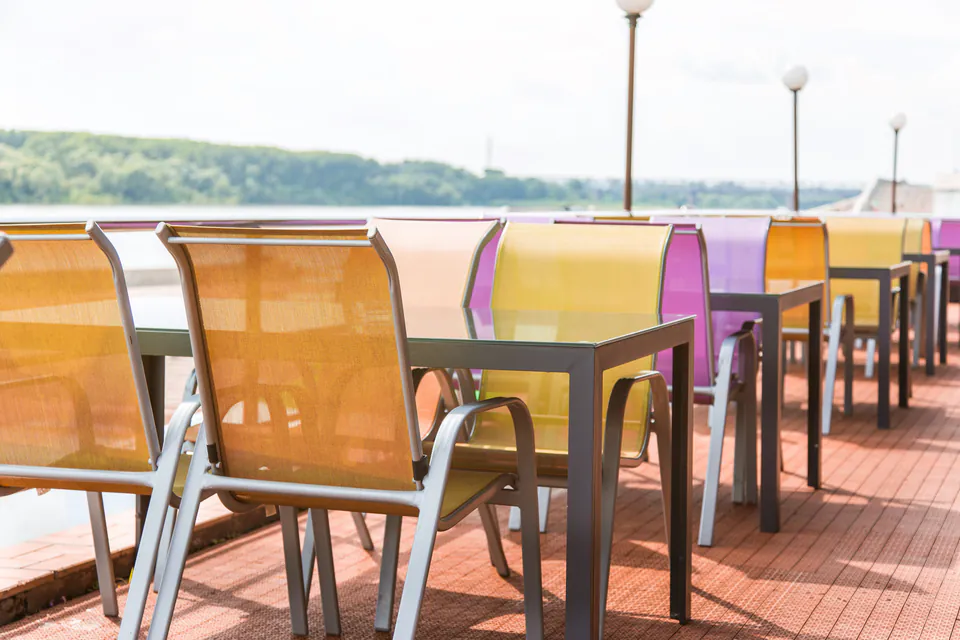 Outdoor terrace with colorful dining chairs overlooking the Danube River