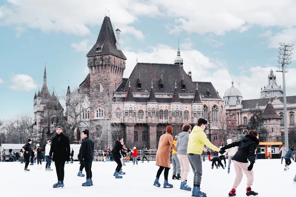 Winter ice skating in City Park with Vajdahunyad Castle backdrop
