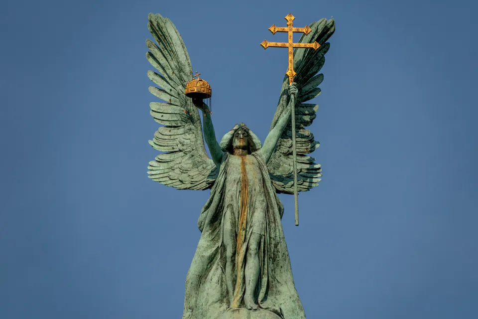 Bronze statue of Archangel Gabriel holding crown and cross atop Millennium Monument