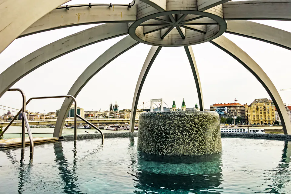 Domed rooftop thermal pool with panoramic views of Budapest's skyline and Danube River