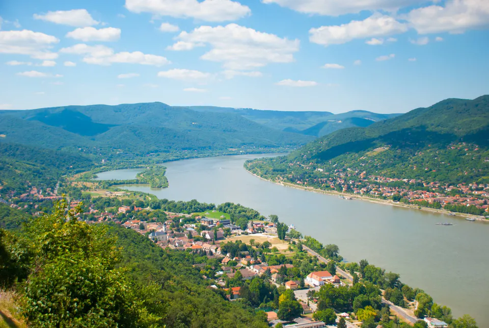 Sweeping view of the Danube River curving between green hills with villages along its banks