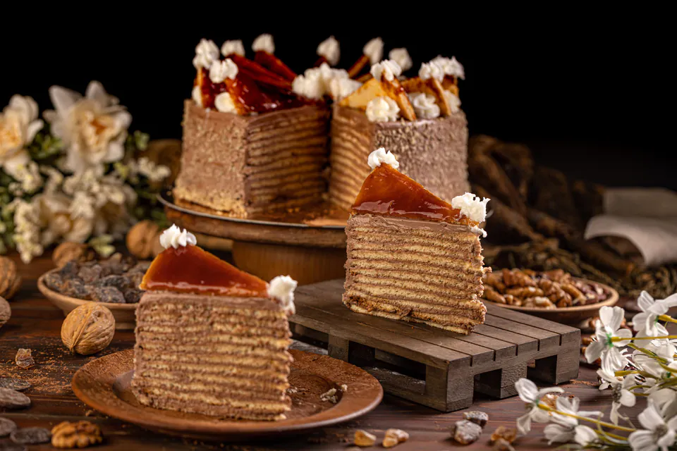 Sliced Dobos Torte displaying multiple thin layers with chocolate buttercream and caramel topping