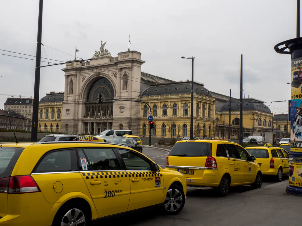 Yellow licensed taxi on Budapest street with Parliament building in background