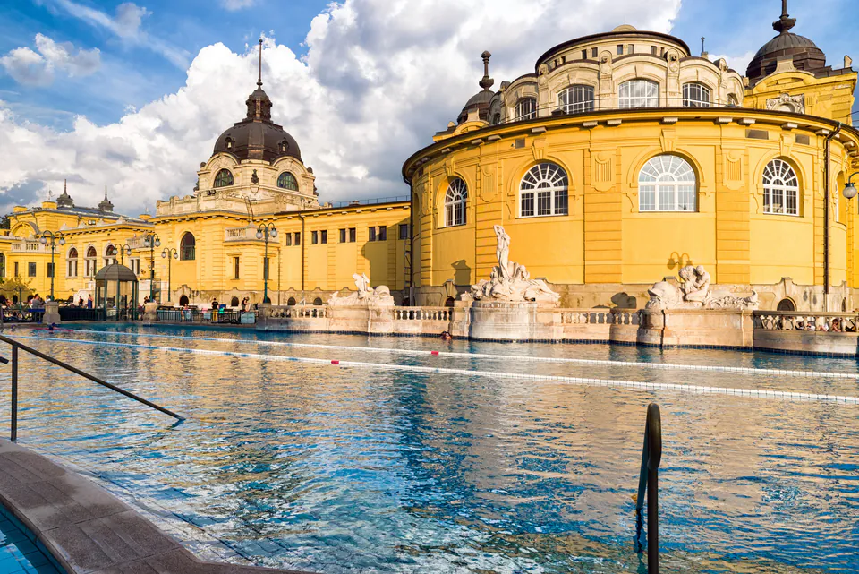 Historic yellow neo-baroque building with outdoor thermal pool and ornate architectural details