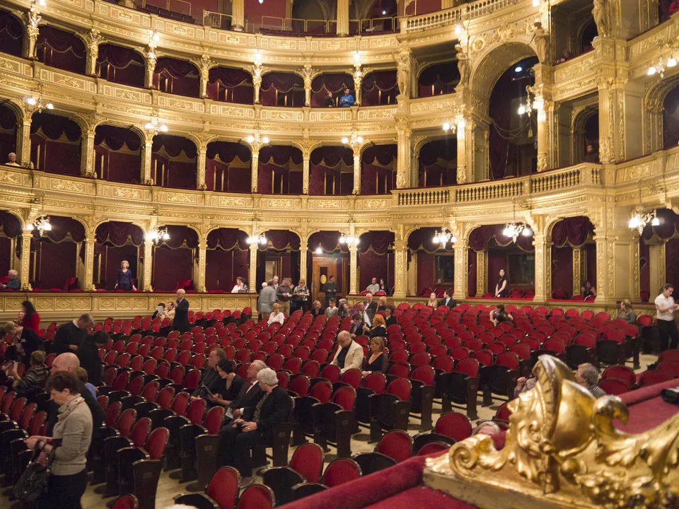 Ornate interior auditorium of Hungarian State Opera House with red seats and gilded balconies